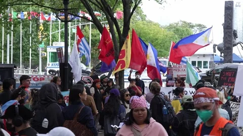 Protesters with flags and signs near UN headquarters 스톡 동영상 346265194