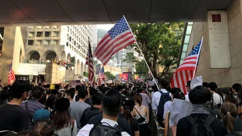 Protesters holding US flag marching to the US consulate in slow motion Stock Footage 115711700