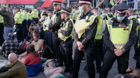 Protesters lay on the street next to rebels in bamboo structures next to police Stock Footage 160151167