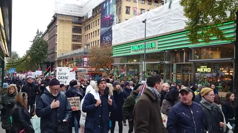 Protesters march against Israel's aggression in Gaza waving flags Stock Footage 256041151