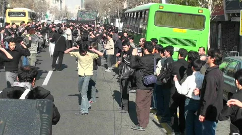 Protesters march down a busy street in Iran. Stock Footage 556549