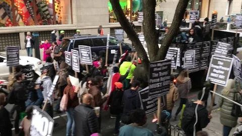 Protesters March down a busy street in New York City Stock Footage 81984604
