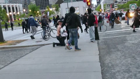 Protesters putting milk in the face of friend after fumigene Stock Footage 132483981