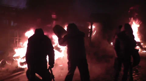 Protesters throw automobile tires in the fire. Stock Footage 39101903