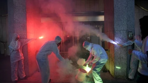 Protesters throw white paint on the windows of a gaming and betting company Stock-Footage 98407052