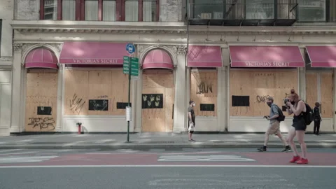 Protesters walking by boarded up stores. Stock Footage 164922901