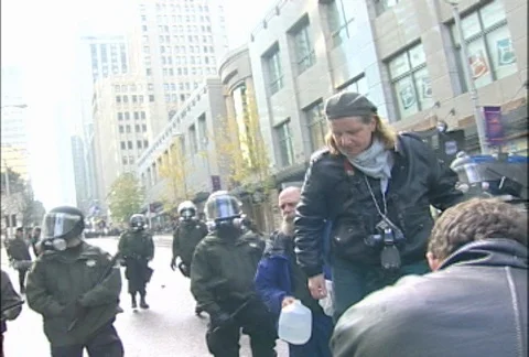 Protesters with Water Jug and Drum near Police Blockade at WTO Protests Stock Footage 106795912