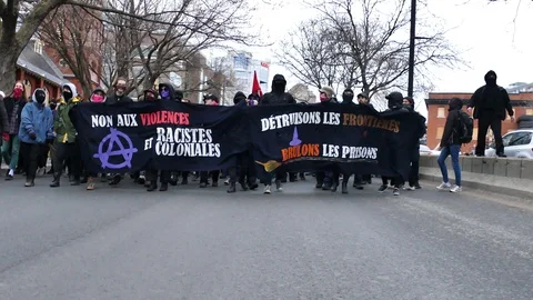 Protesters wearing black clothes approaching Stock Footage 114689071