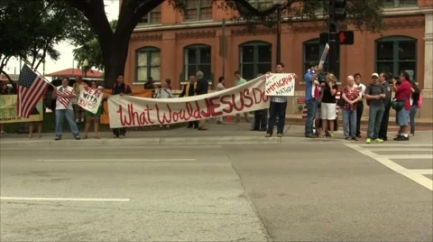 Protesters with What Would Jesus Do sign Stock Footage 57464466