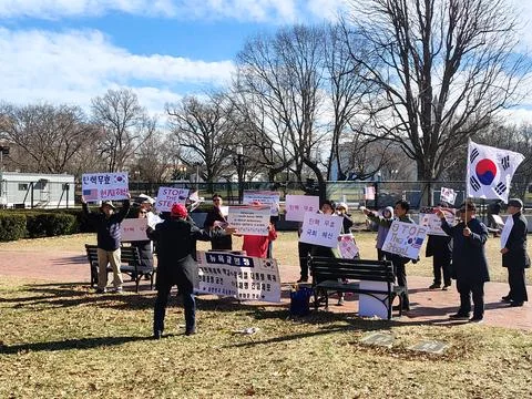 Protesting Koreans in a city park with flags and posters Stock Photos