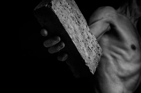 Protesting man throws a brick. Stock Photos