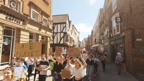 Protesting students with banners march through town 스톡 동영상 108794795