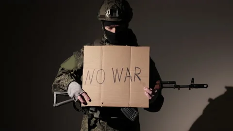 Protesting war conflict raises banner with inscription massage text No War on Stock Footage 221514477