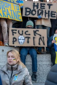 Protestor holding a placard with offensive language against Putin at an anti  Stock Photos