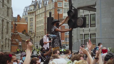 Protestor waving flowers by traffic light in crowd at Black Trans Lives Matter p 動画素材 258268168