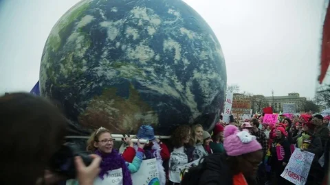 Protestors carry a large globe during Women's March Stock Footage 73779212