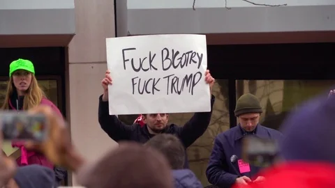 Protestors hold up signs saying a negative pejorative against Trump during an Stock Footage 75696430