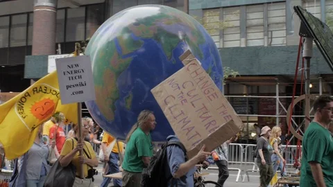 Protestors pulling a rotating earth at a climate change rally in NYC Stock Footage 87787332