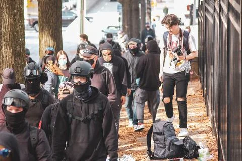Protestors walking down the sidewalk Stock Photos