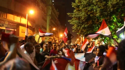 Protestors wave flags and fireworks go off at a nighttime rally in Cairo, Egypt. Stock Footage 25475931