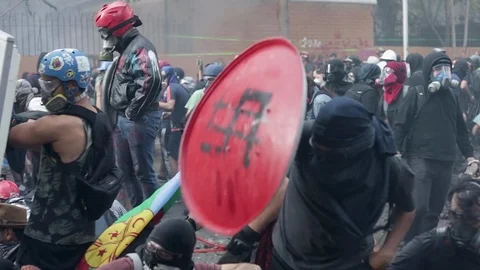 Protestprs use slingshots to fire projectiles at police during a protest Vídeo Stock 124219599