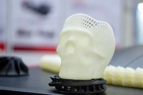 Prototype human skull 3D printed molten white plastic surface close-up Stock Photos