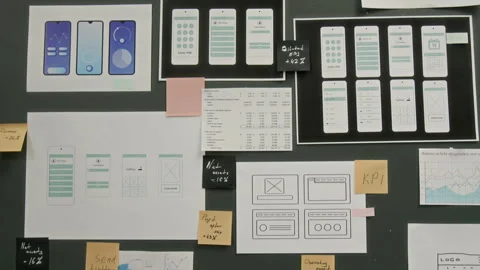 Prototypes of Wireframe Layouts for New Mobile Application on Wall at UX Company Stock Footage 327900422