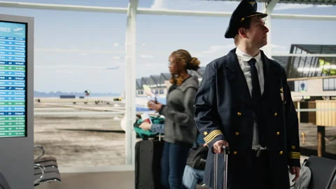 Proud airline captain in pilot uniform standing in busy airport terminal Stock Footage 343736340