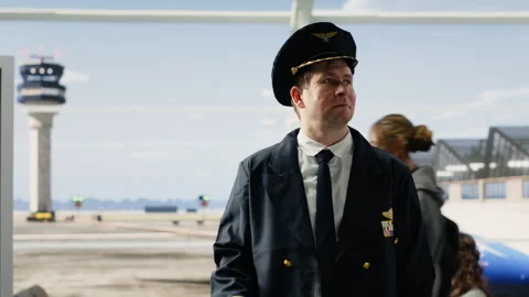 Proud airline captain in pilot uniform standing in busy airport terminal Stock Footage 343738967