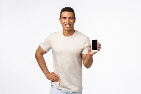 Proud and assertive handsome hispanic man in t-shirt, holding smartphone Stock Photos