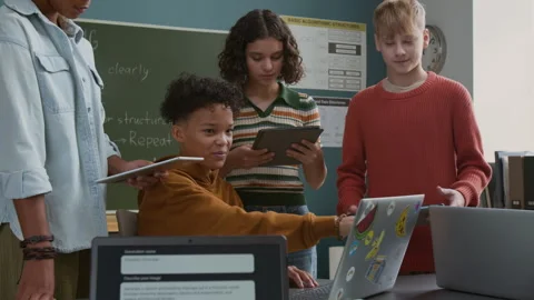 Proud Black Boy Demonstrating Coding Project on Laptop to Classmates Stock Footage 318714136