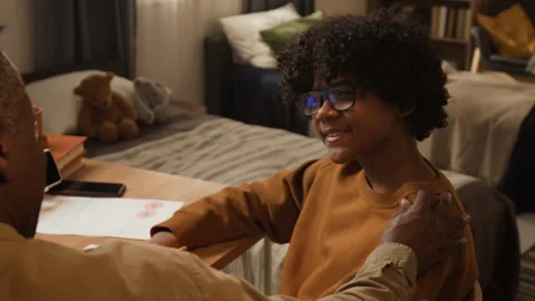 Proud Black Boy Discussing Study Achievements with Supportive Father Stock Footage 334967679