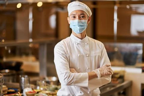 Proud chef posing in his workplace near the kitchenware Stock Photos