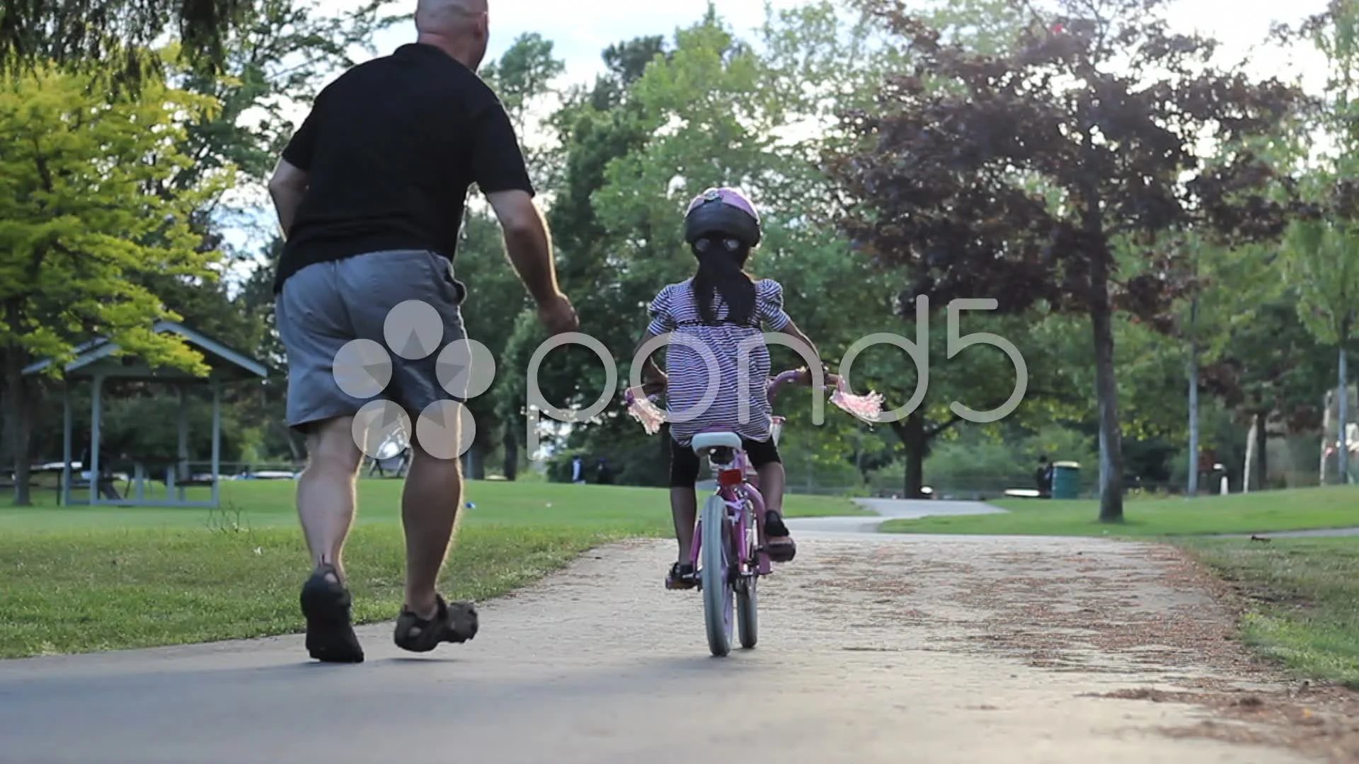 Proud Father Encourages Daughter Riding Her Bike