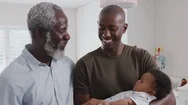Proud Grandfather With Adult Son Cuddling Baby Grandson In Nursery At Home Stock Footage