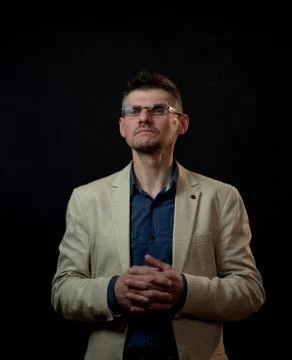 Proud guy in glasses poses for camera twisting fingers Stock Photos