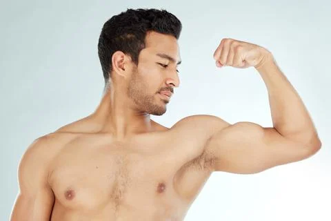 Proud of his progress. a man flexing his biceps against a studio background. Stock Photos