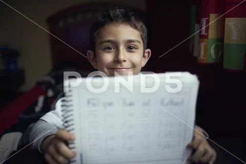 Proud Hispanic boy practicing writing alphabet Stock Photos
