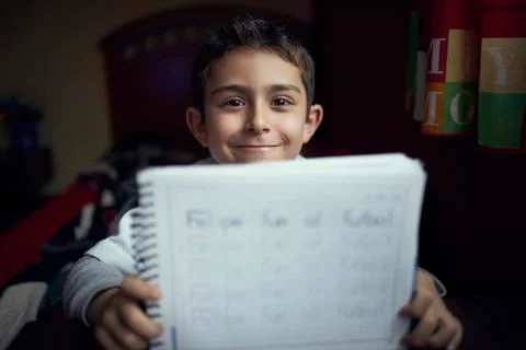 Proud Hispanic boy practicing writing alphabet Stock Photos