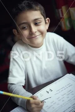 Proud Hispanic boy practicing writing alphabet Stock Photos