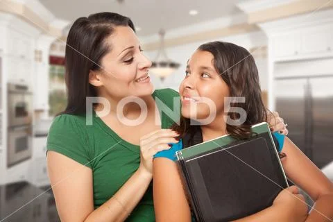 Proud Hispanic Mother and Daughter In Kitchen at Home Ready for School. Stock Photos