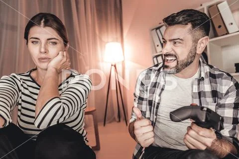 Proud man and sad woman playing a video game Stock Photos