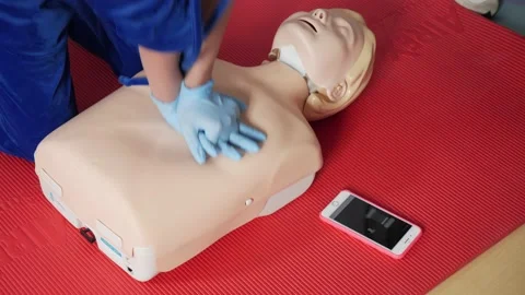 Providing first aid in case of cardiac arrest on a dummy Stock Footage 234108673