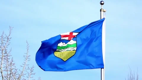 The provincial flag of Alberta fluttering on a silver flagpole against a clear Stock Footage 331415075