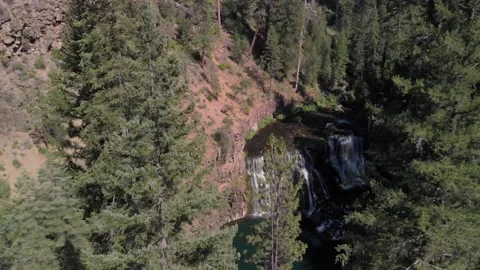Proximity aerial through tree tops to reveal beautiful McCloud Falls Stock Footage 146843953