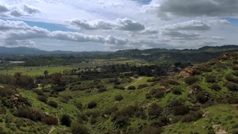 Proximity flight down lush grassy hillside hiking trails Stock Footage 241552521