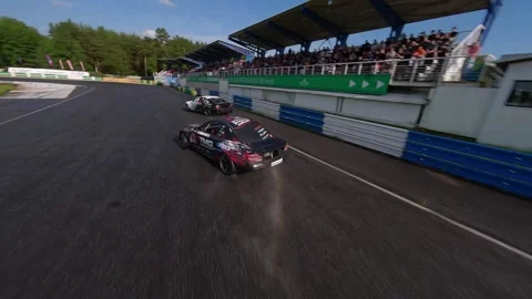 Proximity FPV Drone Chase of Aggressive Tandem Drift on Wet Track Stock-Footage 336101531