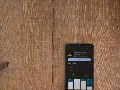 Proxmox Virtual Environment app play store page on smartphone on wooden bac.. Stock Photos