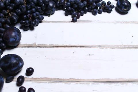 Prunes and grapes on the table Stock Photos