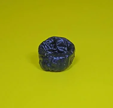 Prunes on a yellow background, one object. Stock Photos
